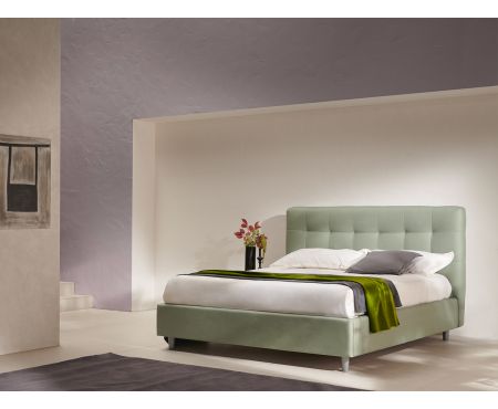 Letto matrimoniale contenitore Dubai con testiera imbottita a motivo a quadri, piedini conici e struttura in tessuto, presentato in una camera da letto elegante. Collezione LoveKasa